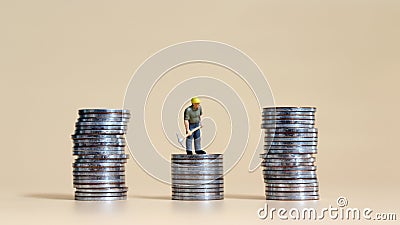 Business concept with a miniature person with a pile of coins. Stock Photo